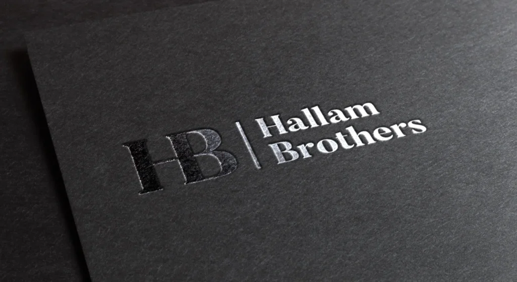 New Hallam Brothers logo shown as silver foil stamp on black card.