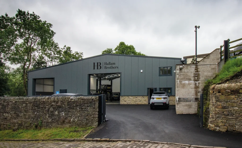 Hallam Brothers new vehicle maintenance unit sign shown by day.