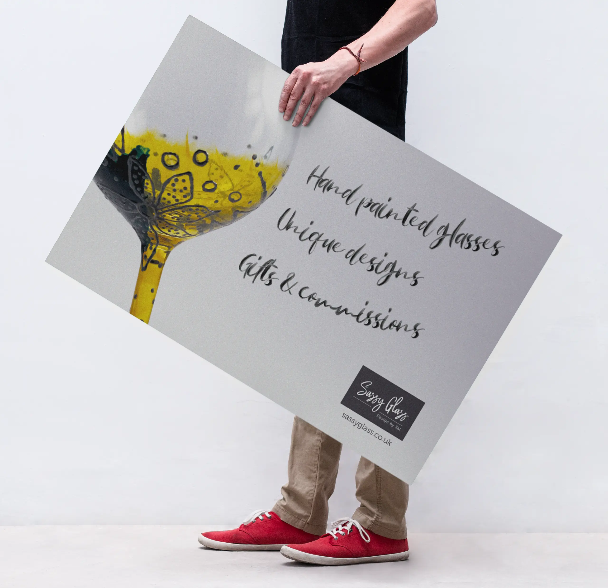 Man holding a Sassy Glass promotional poster.